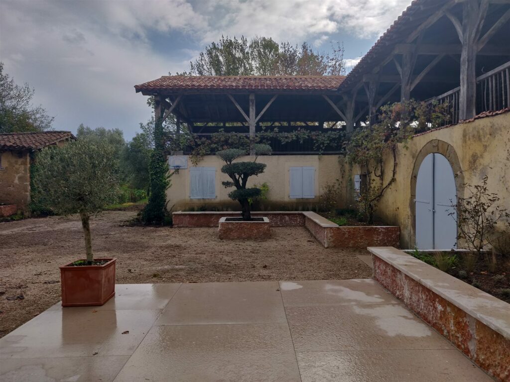 Cour aménagée en pierre de Bourgogne Comblanchien, avec muret bas et olivier en bac